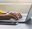 Adult searching for a safe senior living community on her laptop